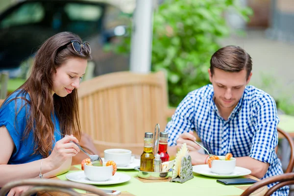 Restaurant tourists couple eating at outdoor cafe. Young woman and her friend enjoy their food at lunch time — Stock Photo, Image