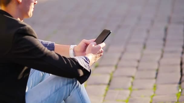 Zbliżenie męskich rąk trzyma komórkę na zewnątrz na ulicy. Mężczyzna korzystający ze smartfona. — Wideo stockowe