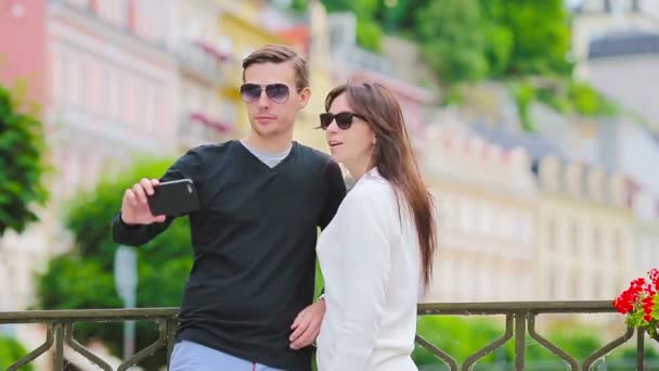 Selfie 写真白人カップルがヨーロッパを旅行します。ロマンチックな旅行女と男愛の笑顔で幸せを取ってプラハの休日休暇の間に屋外のセルフ ポートレート — ストック動画