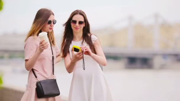 Kafkasyalı kızlar selfie arka planında büyük bir köprü yapıyorlar. Genç turist arkadaşlar tatilde dışarıda mutlu bir şekilde seyahat ediyorlar.. — Stok video