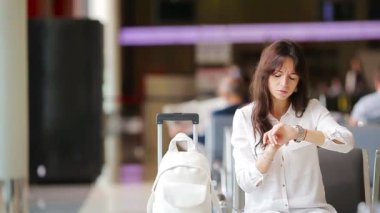 Havaalanı lobisindeki yolcu uçuş için bekliyor. Beyaz kadın bekleme odasında zaman geçirmek istiyor.