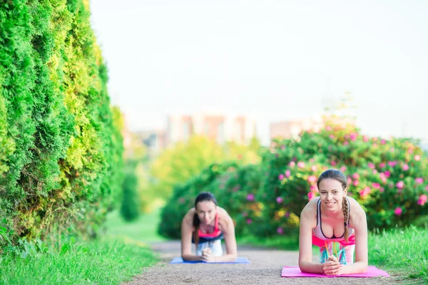 Esporte fitness mulheres treinamento flexões. Atleta feminina exercitando empurrar para fora no parque vazio. Apto modelo de fitness menina em crossfit exercício ao ar livre. Conceito de estilo de vida saudável . — Fotografia de Stock