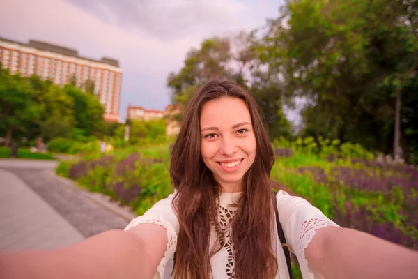 Joven mujer caucásica haciendo selfie en atracciones fondo al aire libre. Chica feliz disfrutar de su fin de semana en la ciudad europea —  Fotos de Stock