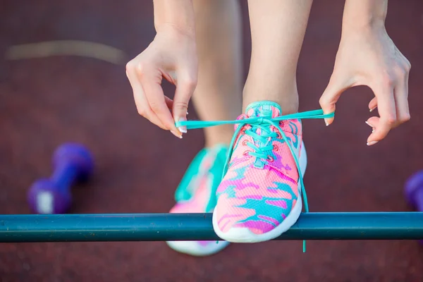 健康的なアクティブなライフ スタイルの女性選手がランニング シューズを結ぶします。スポーティな女の子は、トレーニングをジョギングの準備します。ランニング シューズのクローズ アップ. — ストック写真