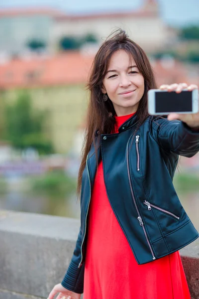 Jonge blanke vrouw maakt selfie op attracties achtergrond buiten. gelukkig meisje genieten van haar weekend in europees stad — Stockfoto