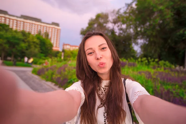 Menina fazendo selfie vídeo e se divertindo no parque. Estilo de vida selfie retrato de jovem mulher positiva se divertindo e tomando selfie. Diversão de conceito com novas tendências e tecnologia . — Fotografia de Stock