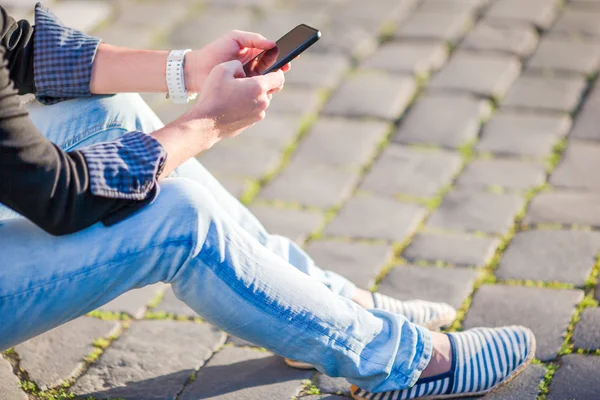 Närbild av manliga händer håller mobiltelefon utomhus på gatan. Man använder mobiltelefon. — Stockfoto