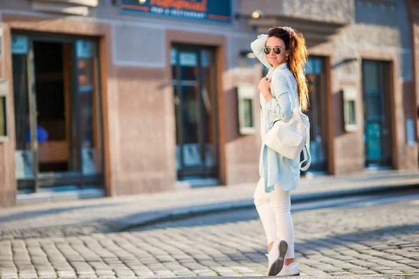 Mujer urbana joven y feliz en la ciudad europea. Turista caucásico caminando por las calles desiertas de Europa. Cálido verano por la mañana temprano en Praga, República Checa — Foto de Stock