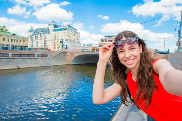 Ung kaukasisk kvinna gör selfie på attraktioner bakgrund utomhus. Glad flicka njuta av sin helg i europeiska staden — Stockfoto