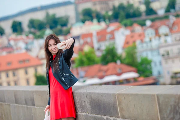 Mulher caucasiana jovem fazendo selfie em atrações de fundo ao ar livre. Menina feliz desfrutar de seu fim de semana na cidade europeia — Fotografia de Stock