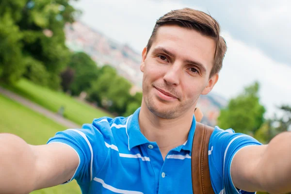 Joven hombre caucásico haciendo selfie fondo europeo ciudad vieja por teléfono móvil desde el lugar de observación — Foto de Stock