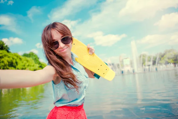 Jovencita divirtiéndose con monopatín en el parque. Retrato de estilo de vida de una joven mujer positiva divirtiéndose y disfrutando del clima cálido . —  Fotos de Stock