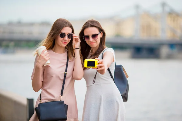Blanke meisjes maken selfie achtergrond grote brug. Jonge toeristische vrienden op vakantie buiten glimlachend gelukkig. — Stockfoto