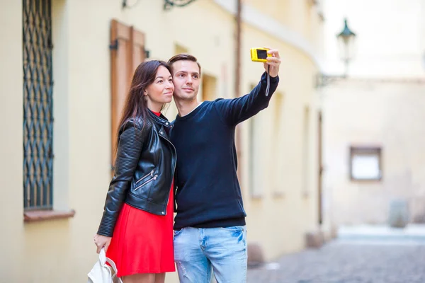 Casal jovem viajando em férias na Europa sorrindo feliz. Família caucasiana fazendo selfie em ruas velhas vazias europeias — Fotografia de Stock