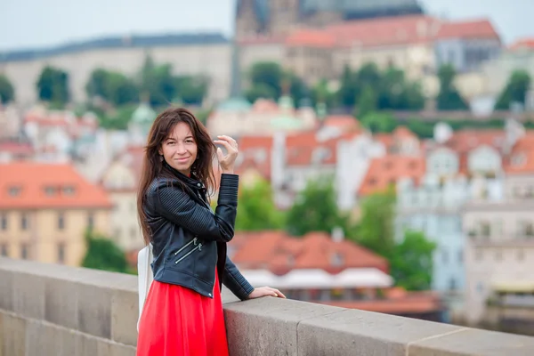 Lycklig ung Urban kvinna i europeisk stad på den berömda bron. Kaukasiska turist promenader längs de övergivna gatorna i Europa. Varm sommar tidigt på morgonen i Prag, Tjeckien — Stockfoto
