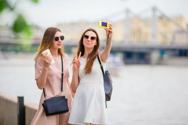 Caucasian girls making selfie background big bridge. Young tourist friends traveling on holidays outdoors smiling happy. — Stock Photo, Image