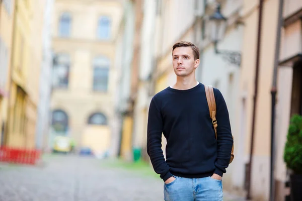 Turista caucásico caminando por las calles desiertas de Europa. Joven chico urbano de vacaciones explorando la calle empedrada de la ciudad europea —  Fotos de Stock