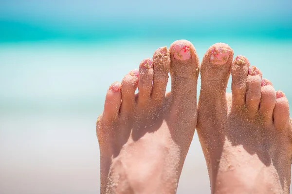 Close up van vrouwelijke voeten op wit zandstrand — Stockfoto