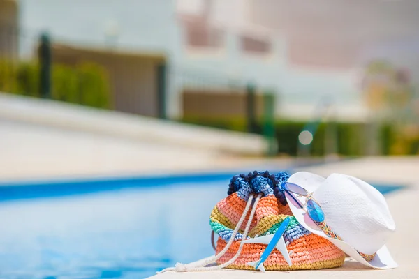 Kleurrijke strandtas, glas sap, stro hoed en vliegtuig model in vrouwelijke hand op zomervakantie — Stockfoto