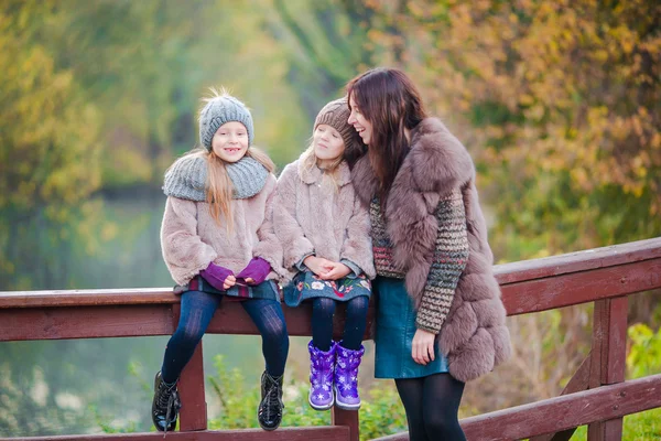 Adorable little girls with mother in autumn park outdoors. Family of three enjoy warm day — Stock Photo, Image