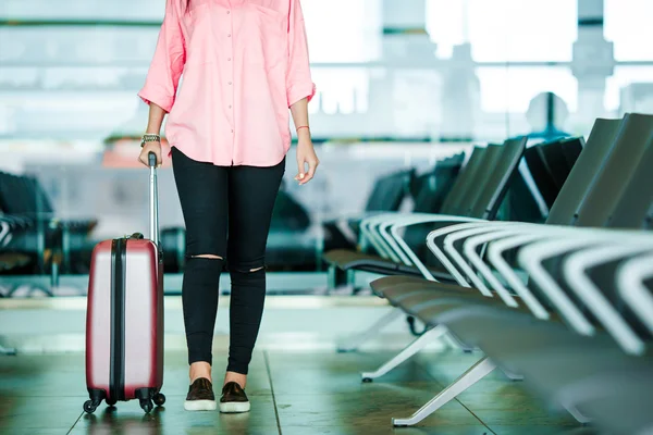 Vértes repülőgép utas útlevél és a beszállókártyáját és a rózsaszín poggyász airport Lounge-ban. Fiatal nő séta a csomagokkal nemzetközi repülőtér. — Stock Fotó