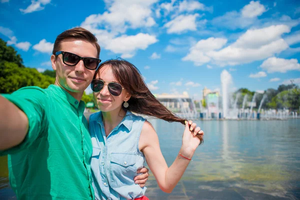 一对年轻的游客夫妇在欧洲度假时开心地笑着.白人女孩和男人自己制造喷泉背景 — 图库照片
