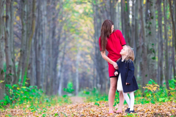 Bedårande liten flicka med mamma i höst park utomhus — Stockfoto