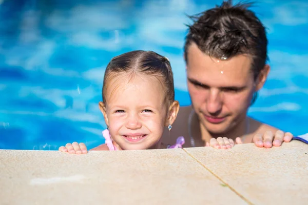 若いお父さんと小さな娘の夏休みを楽しんでいるスイミング プールで演奏 — ストック写真