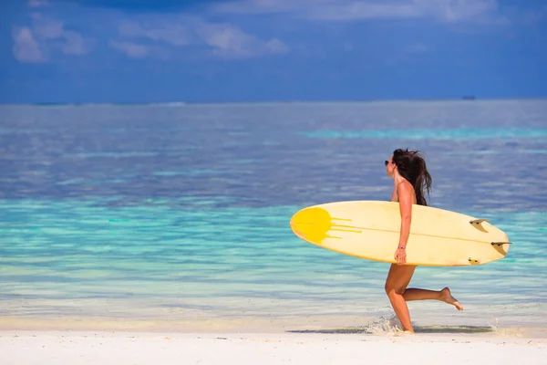 Mutlu genç kadın bir surfboard ile plajda sörf — Stok fotoğraf