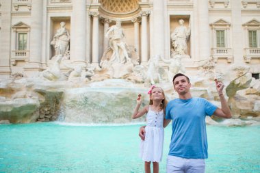 Mutlu aile Trevi Çeşmesi, Roma, İtalya iyi şanslar için sikke trowing. Mutlu aile Avrupa'da İtalyan tatil keyfini çıkarın. Küçük kız ve baba geri dönmek için bir dilek yapıyor.