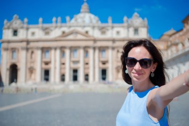 Mutlu genç kadın Vatikan'da St Peters Bazilikası kilisede selfie çekerken, Roma. İtalya'da Avrupa tatilinde selfie fotoğrafı çeken beyaz turist.