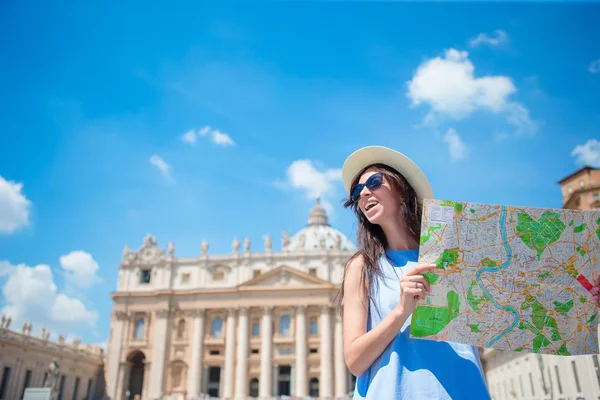 바티칸 시와 이탈리아 로마 성 페터스 바실리카 교회에서 도시 지도를 갖고 있는 행복 한 젊은 여성. 유럽의 휴일에 야외에서 지도를 가지고 있는 여행하는 여경. — 스톡 사진