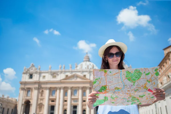 Szczęśliwa młoda kobieta z mapą miasta w Watykanie i kościół Bazyliki św. Piotra, Rzym, Włochy. Turystka podróżująca z mapą na świeżym powietrzu podczas wakacji w Europie. — Zdjęcie stockowe