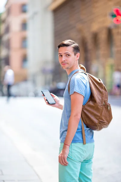 Kaukasische toeristische met smartphone in handen lopen langs de straten verlaten Italiaans in Rome. Stedelijke jongen op vakantie verkennen Europese stad — Stockfoto