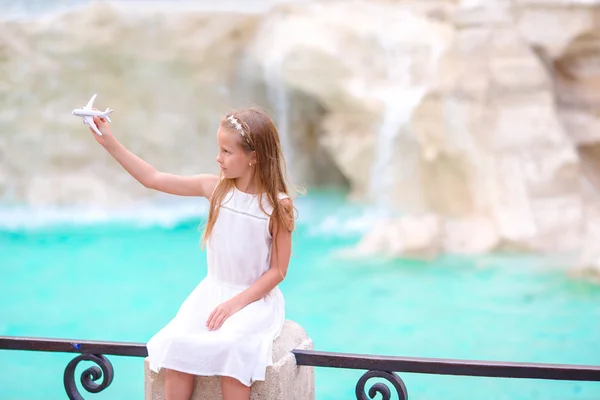 Чарівної маленької дівчинкою з іграшковий літак фоном фонтану Треві, Рим, Італія. Toodler щаслива дитина італійський відпочинок відпочинок мають на ринки Європи. — стокове фото