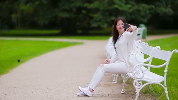 Retrato de mujer hermosa usando teléfono inteligente al aire libre . — Vídeos de Stock