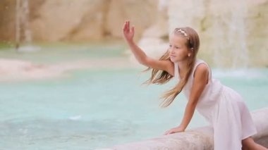 Roma 'daki Trevi Çeşmesi' nin yanındaki sevimli küçük kız. Mutlu çocuk İtalya 'da Avrupa tatilinin tadını çıkarıyor
