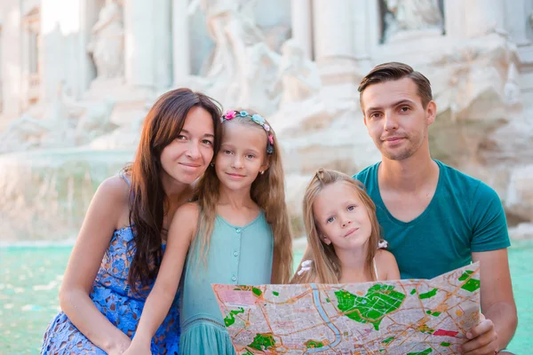 Retrato de familia con mapa turístico cerca de Fontana di Trevi, Roma, Italia. Padres y niños felices disfrutan de vacaciones italianas en Europa . — Foto de Stock