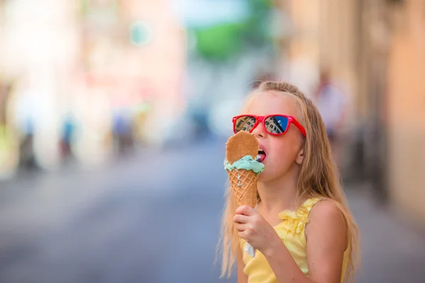 Adorável menina comendo sorvete ao ar livre no verão. Miúdo bonito desfrutando de gelato italiano real perto de Gelateria em Roma — Fotografia de Stock