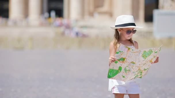 Adorable niña con mapa turístico en la plaza de la Basílica de San Pedro, Italia. Feliz niño toodler disfrutar de vacaciones italianas en Europa . — Vídeo de stock