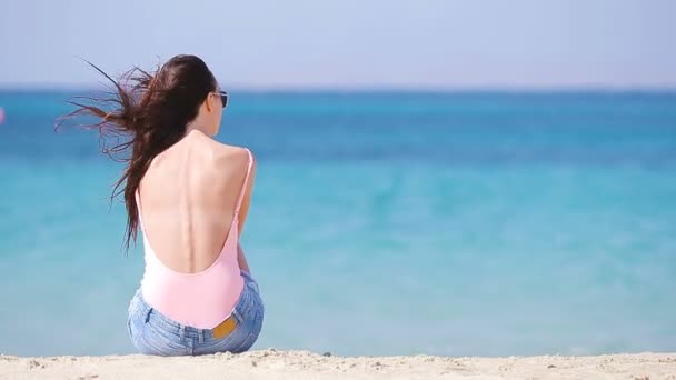 Jovem mulher bonita na praia durante as férias tropicais. Menina desfrutar de seu wekeend em uma das belas praias em Mykonos, Grécia, Europa . — Vídeo de Stock