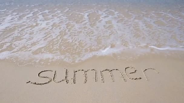 Λέξη καλοκαίρι χειρόγραφα σε αμμώδη παραλία με μαλακοί ωκεάνιοι κύμα σε φόντο — Αρχείο Βίντεο
