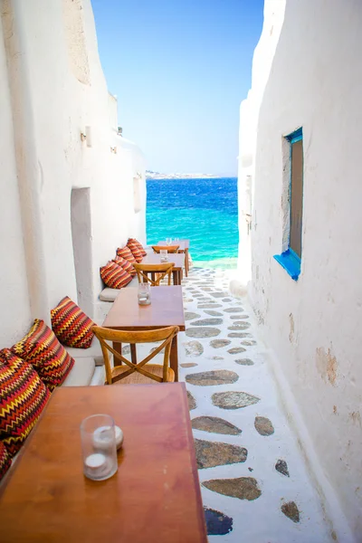 在米科诺斯典型的希腊酒吧配有枕头的长椅，在基克拉泽斯群岛上享有令人惊叹的海景 — 图库照片