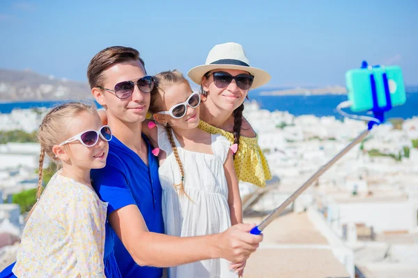 Rodzinne wakacje w Europie. Rodzice i dzieci biorąc selfie zdjęcie tło miasta Mykonos w Grecji — Zdjęcie stockowe