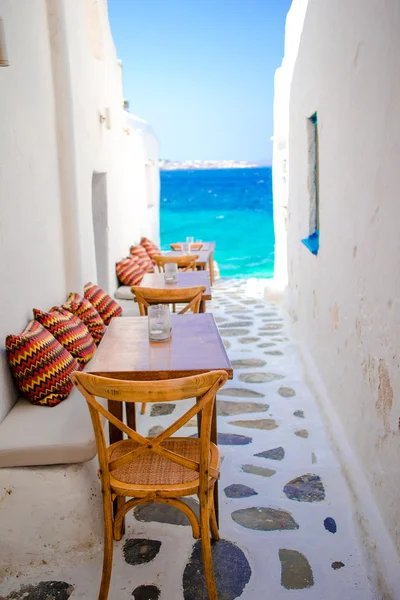 Bancos con almohadas en un típico bar griego en Mykonos con increíbles vistas al mar en las islas Cícladas —  Fotos de Stock