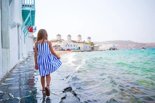 Schattig meisje op klein Venetië het meest populaire toeristische centrum op het eiland Mykonos, Griekenland. Mooie jongen glimlachen en kijken in de camera op Little Venice achtergrond. — Stockfoto