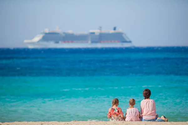 Giovane madre felice e le sue adorabili figlie sulla spiaggia esotica nella giornata di sole — Foto Stock