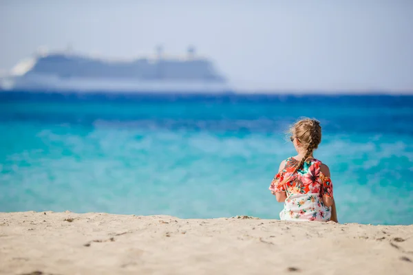 Маленькая девочка на пляже фоне большой лайнер — стоковое фото