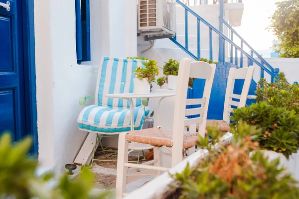 Las estrechas calles de la isla con balcones azules, escaleras y flores. Hermosa terraza exterior con estilo cicládico . —  Fotos de Stock