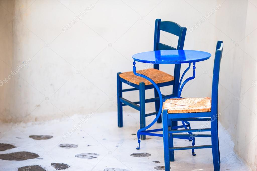 Two blue chairs on a street of typical greek traditional village on Mykonos Island, Greece, Europe